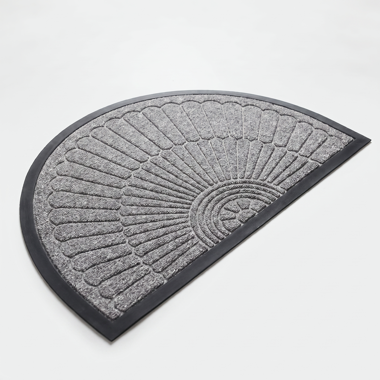 Light grey crescent half-moon door mat with embossed sunburst design and black rubber border on a clean off-white background