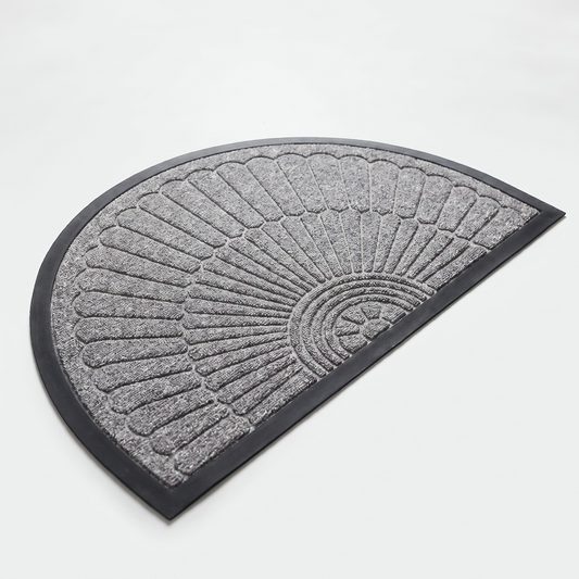 Light grey crescent half-moon door mat with embossed sunburst design and black rubber border on a clean off-white background