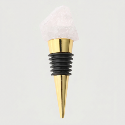 Clear quartz crystal bottle stopper with a black rubber sleeve on a light gray background