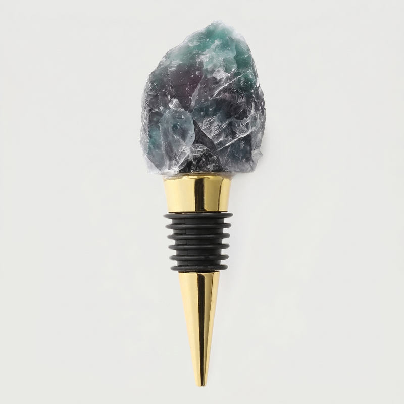 Fluorite crystal bottle stopper with gold tip on a light gray background