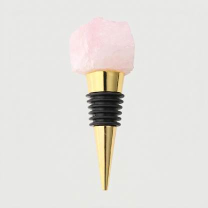 Rose quartz crystal wine bottle stopper with gold stainless steel stopper on a light gray background