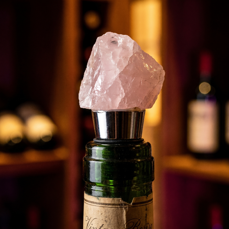 Rose quartz bottle stopper in bottle of wine.