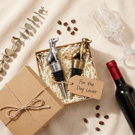 Dog wine bottle stoppers with a gift box and wine bottle on a beige surface.