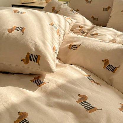 Close-up of rumpled dachshund-print pillows and duvet folds in warm light