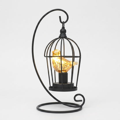 Single Bird illuminated birdcage with a glowing amber glass bird on a white background