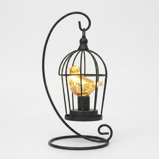 Single Bird illuminated birdcage with a glowing amber glass bird on a white background