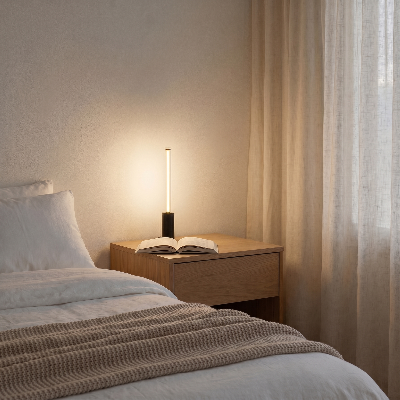 Dimmable rechargeable night light on bedside table in softly lit bedroom