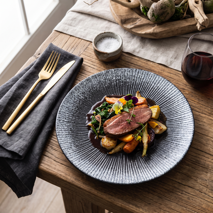 Blue disc ceramic plate with a plated meal on a dining table