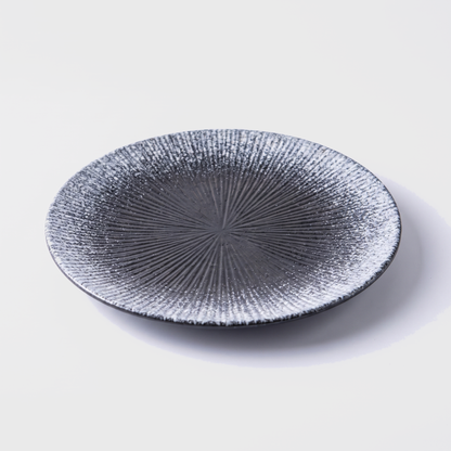 Gray disc ceramic dinner plate with radial ridged design on an off-white background