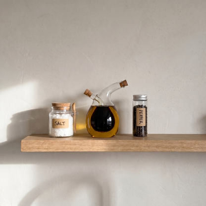 Dual oil and vinegar bottle on floating shelf with bowls and bottles