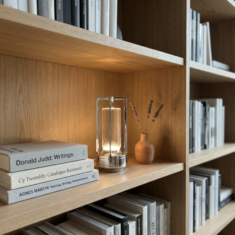 Gold Elio cordless metal table lamp on bookshelf with books