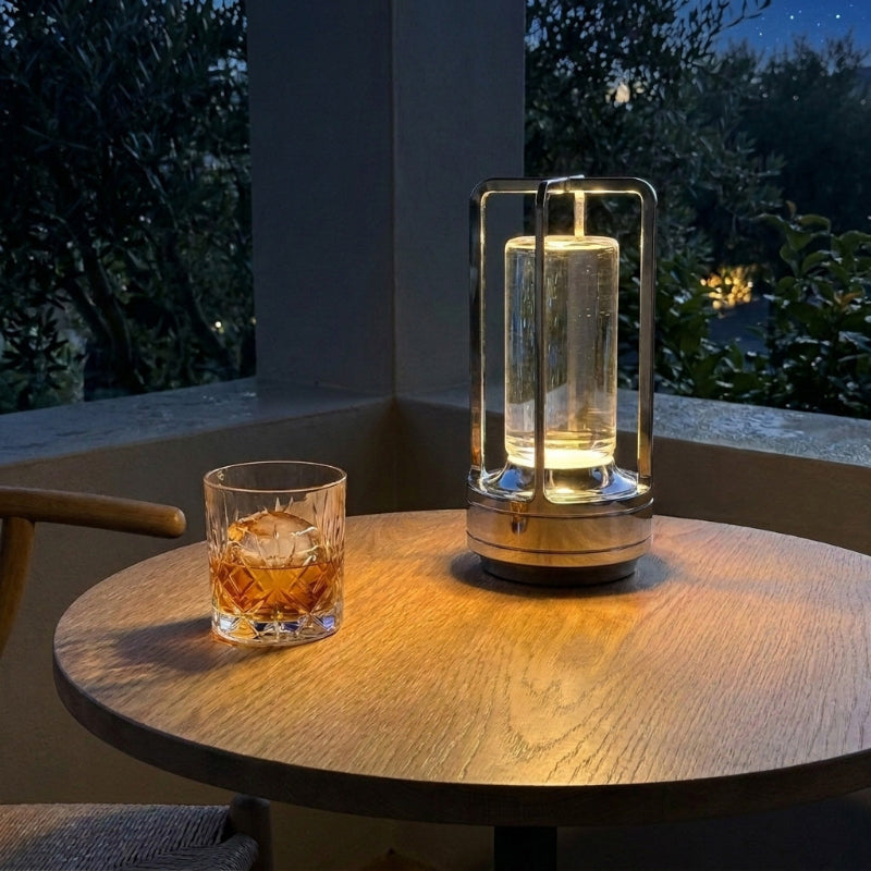 Gold Elio cordless metal table lamp on outdoor table at night