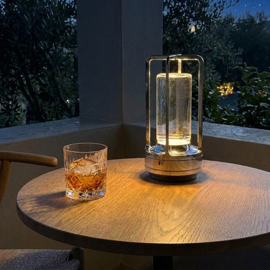 Gold Elio cordless metal table lamp on outdoor table at night
