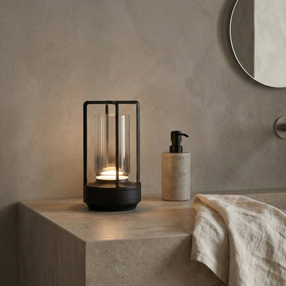 Modern black lantern-style lamp on a concrete surface with a neutral background