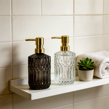 Black and clear facet glass soap dispensers on bathroom shelf
