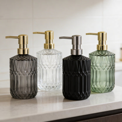 Facet glass soap dispensers in black, smoke, and green on white counter