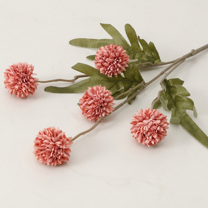 Coral faux dandelion stems on white background