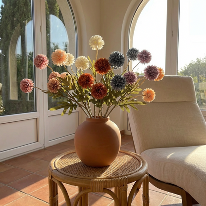 Faux dandelion stems in terracotta vase by window
