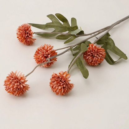 Orange faux dandelion stems on white background