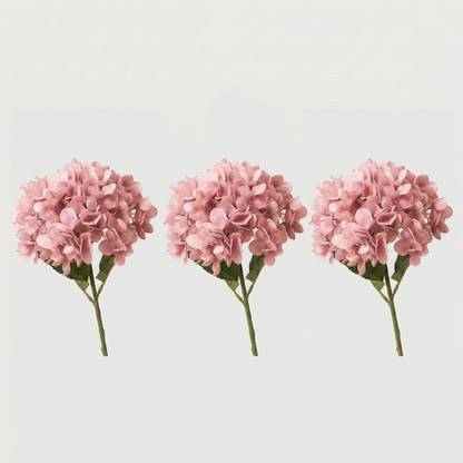 Three pink faux hydrangea stems on white background