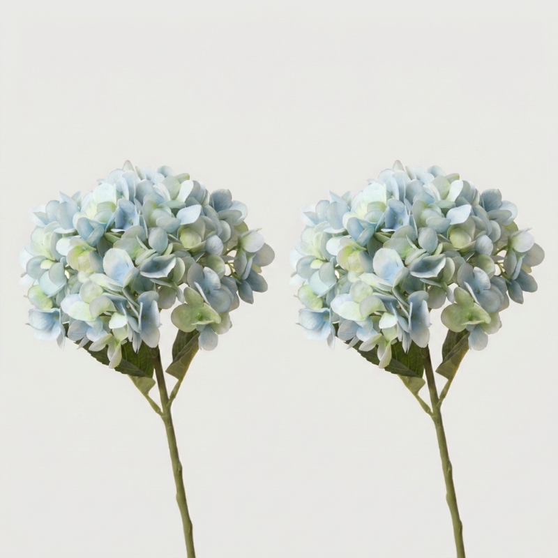 Two blue faux hydrangea stems on white background