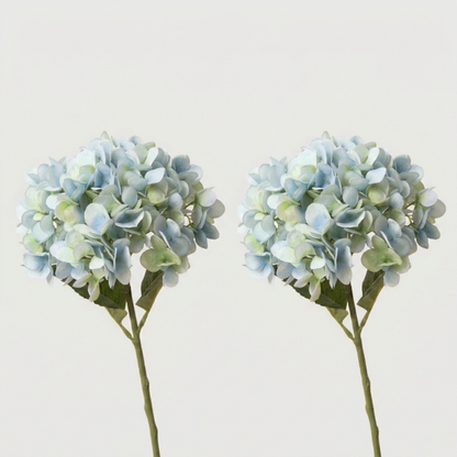 Two blue faux hydrangea stems on white background