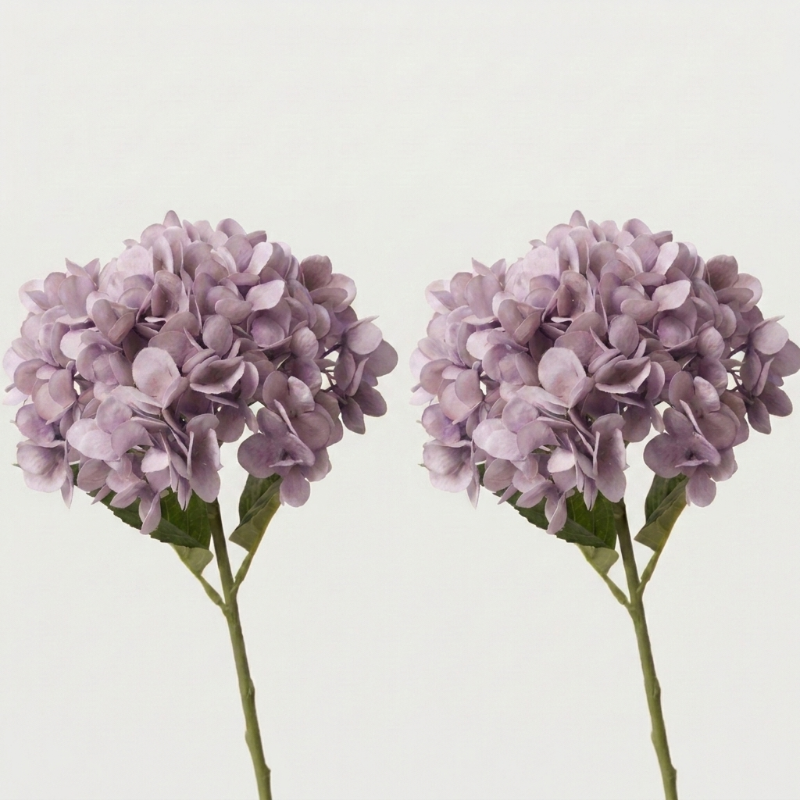Two purple faux hydrangea stems on white background