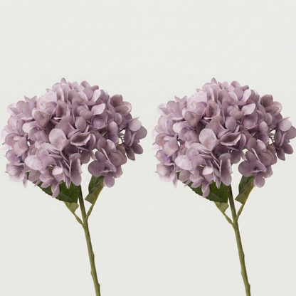 Two purple faux hydrangea stems on white background