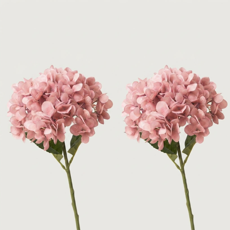 Two pink faux hydrangea stems on white background