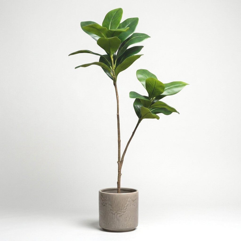 Two faux magnolia tree stems in a taupe ceramic pot with an embossed leaf pattern, on a plain studio background