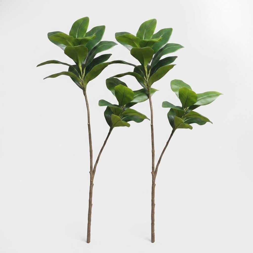 Two faux magnolia tree stems standing side by side on a plain studio background