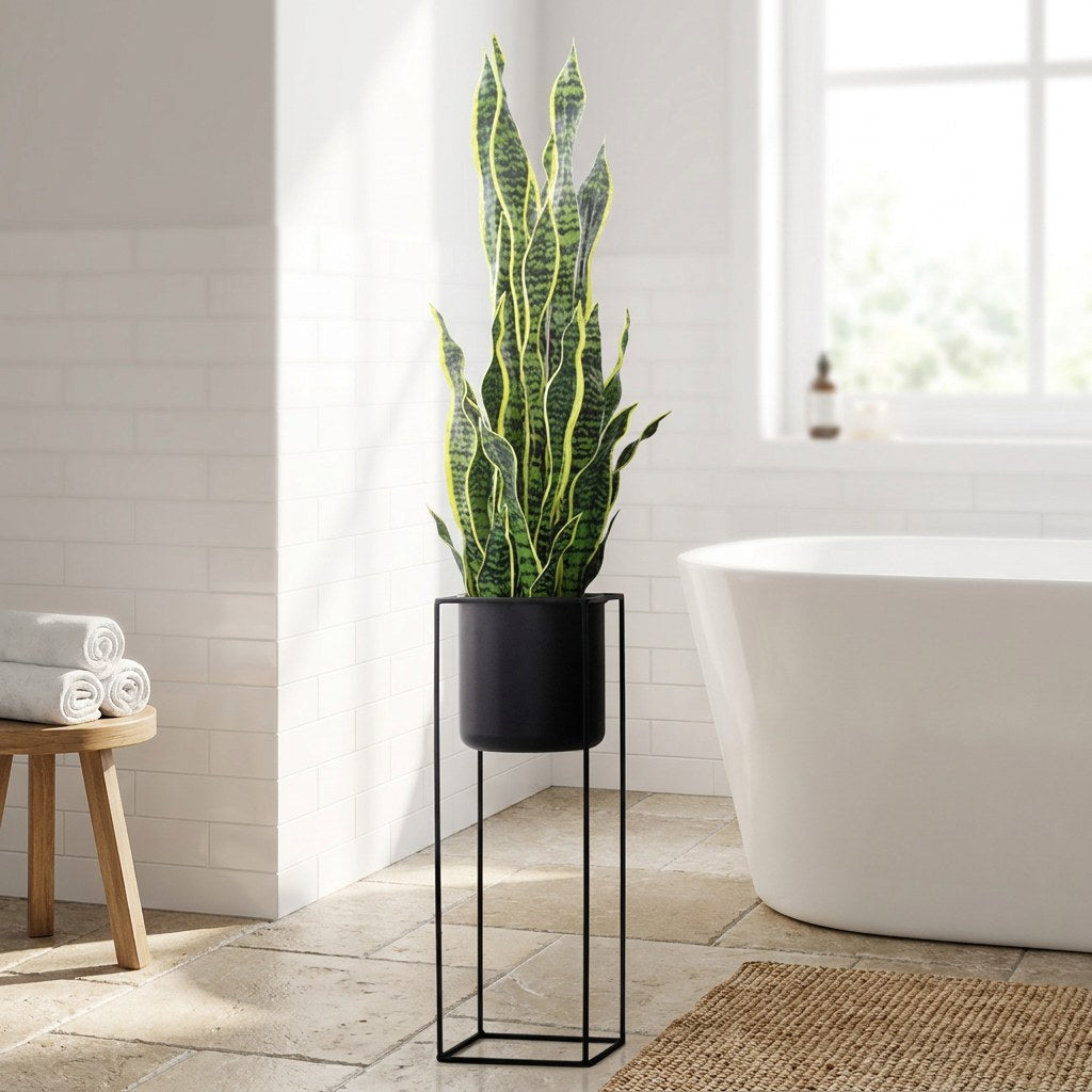 Faux snake plant in a black planter on a black metal stand beside a soaking tub in a white tiled bathroom