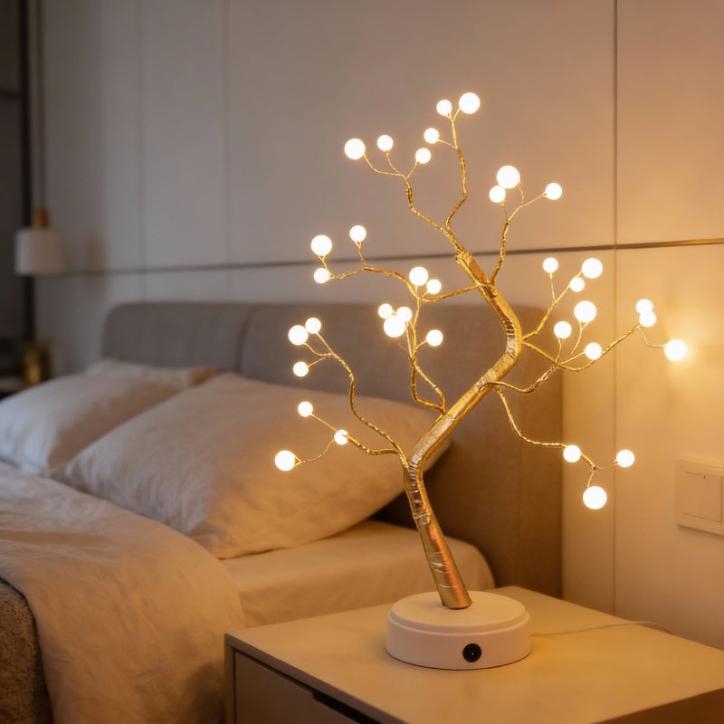 Decorative LED tree on a nightstand with a bed in the background