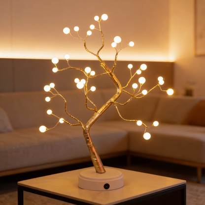 Decorative LED tree on a table with warm lighting in a cozy room.