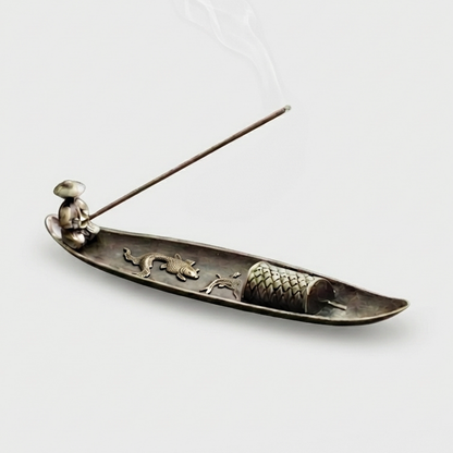 Fishing boat incense burner on white background with incense stick