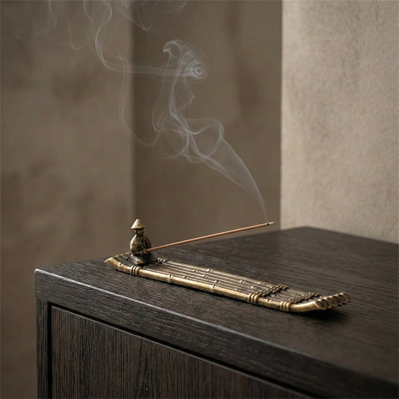 Fishing boat incense burner on dark table with rising smoke