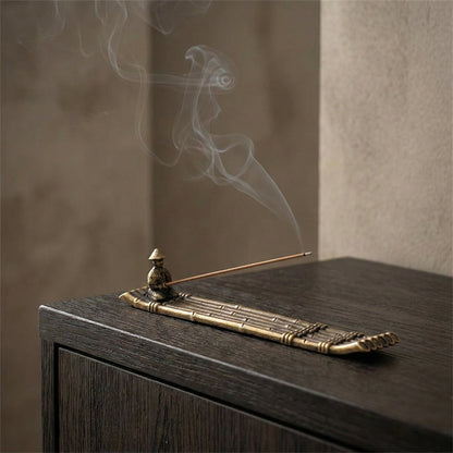 Fishing boat incense burner on dark table with rising smoke