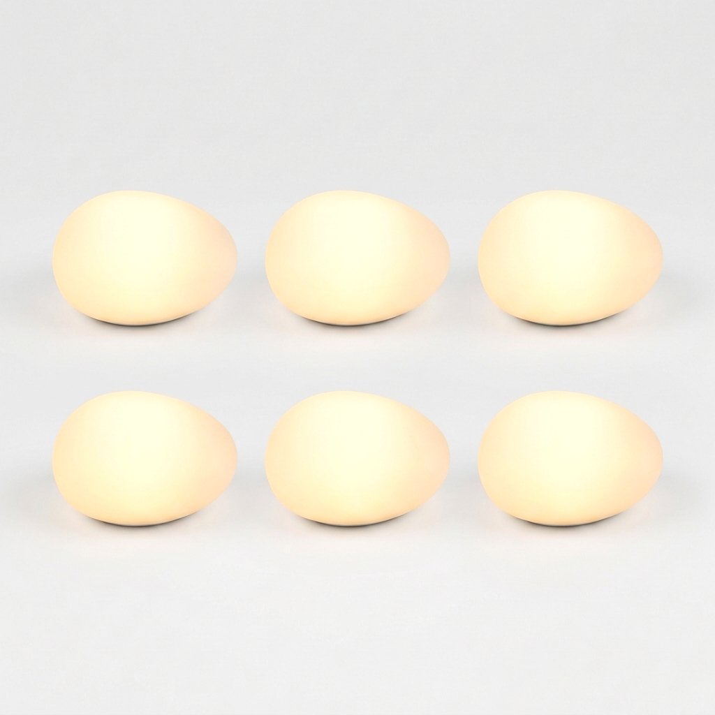 Six frosted solar glass pebble lights glowing warm yellow in a grid of three by two on a light background