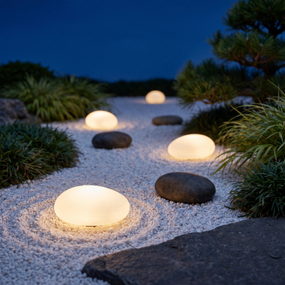 Frosted solar glass pebble lights on white gravel garden path at night