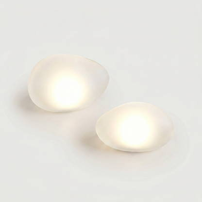 Set of two frosted solar glass pebble lights on white background