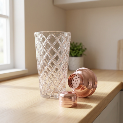 Glass cocktail shaker with copper lid on windowsill
