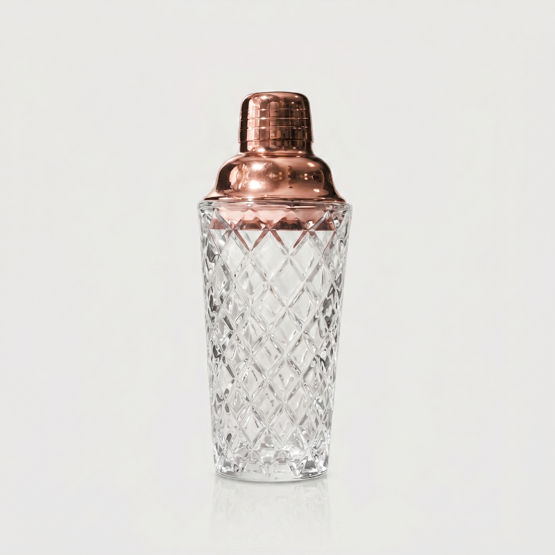 Glass cocktail shaker with rose gold lid on white background