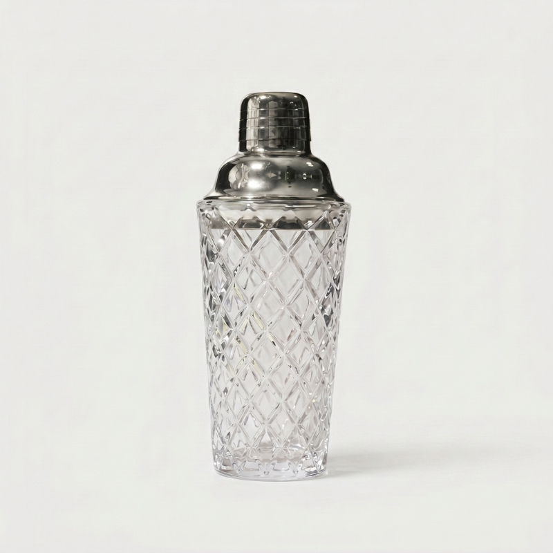 Glass cocktail shaker with silver lid on white background