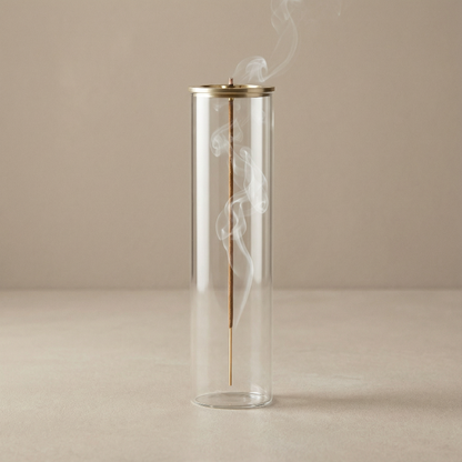 Glass container with a gold accent and smoke on a beige background