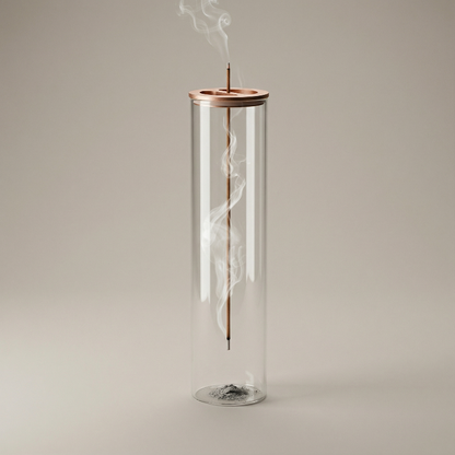 Candle in a glass container with a copper top on a beige background