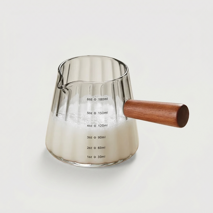 Green glass milk frothing pitcher on white background