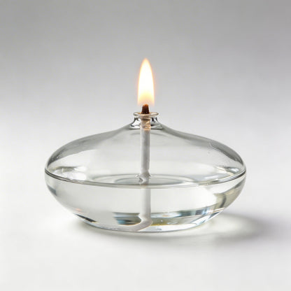 Clear glass oil candle with lit wick