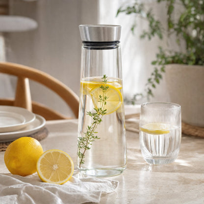 Glass pitcher filled with lemon slices and thyme on an outdoor patio table