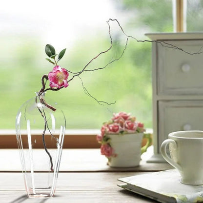 Cylindrical glass vase holding flower stems, creating a calming and minimalist decor piece.