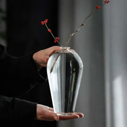 Cylindrical glass vase placed with fresh-cut daisies, letting natural light illuminate its sleek design.